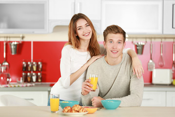 Obraz na płótnie Canvas Couple having breakfast in kitchen