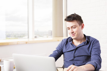 Smiling man using laptop