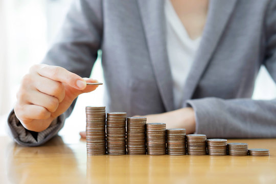 Close-up Of A Businesswoman Making Stack Of Coins
