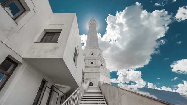 White Tower of the mosque before the sun on a background of blue sky and clouds. Kazakhstan - 4K Timelapse