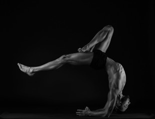 man practicing yoga, studio photo