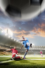 Soccer players in action on sunset stadium background
