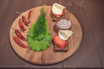 Lettuce and dill on wood plate with rye bread and sea salt
