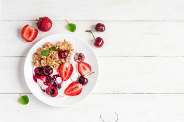 Obraz na płótnie Canvas healthy breakfast with yogurt, muesli and berries, top view, flat lay