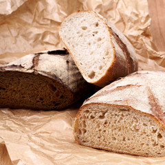 White and brown bread on backers paper and wooden table