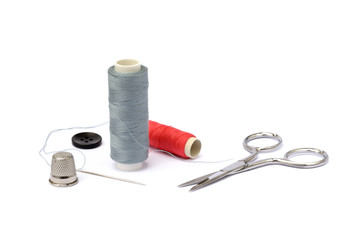 Needle, thimble, scissors, thread and knob isolated on white backgroun