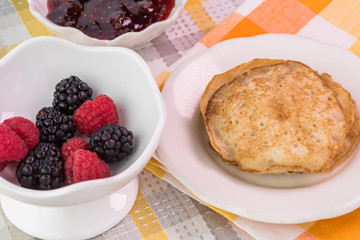 Cornmeal cakes and bowl of fresh berries.