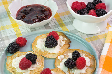 Cornmeal cakes garnish with fresh berries and bowl of berry fig