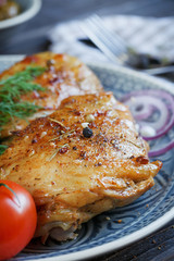 Roasted chicken and vegetables on dark wooden background
