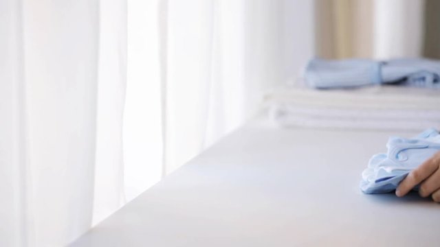 woman hand putting bootees on baby boys clothes 3