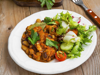 Bean stew with fresh parsley, salad, cucumber, radish and tomato