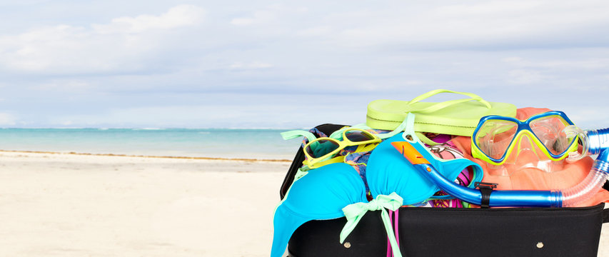 Suitcase with bikini and sunglasses.