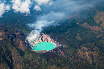 Aerial photo of active volcano Ijen in East Java - largest highly acidic crater lake in world with turquoise sulphuric water. Place of sulfur mining. Famous travel destinations of Indonesian islands.