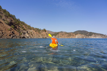 A man traveling by canoe along the coast.