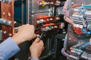 Electrician near the low-voltage cabinet. Uninterrupted power supply. Electricity.