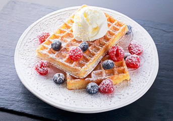 Belgian waffles with ice cream and fresh berries.