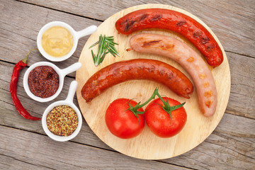 Various grilled sausages with condiments and tomatoes