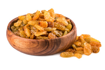 Raisins in a wooden cup on white background. Closeup.