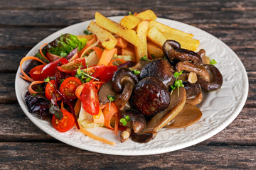 Summer dish with fried chips, red cherry tomatoe salad and grilled wild mushrooms