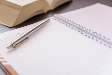 Close-up of open book and pen defocused