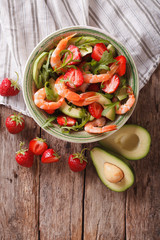 Tasty food: salad with shrimp, avocado and strawberry closeup. vertical top view
