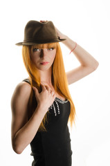 beautiful red-haired girl with a hat in the studio   