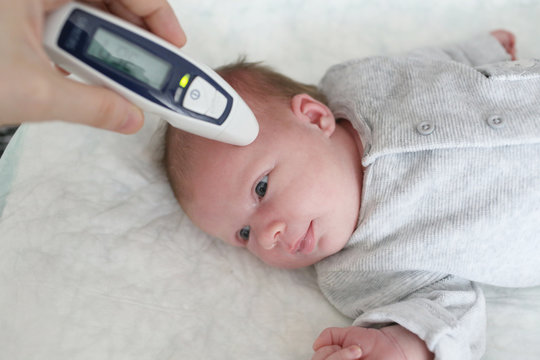 Taking Temperature For Newborn With Infrared Thermometer At Home