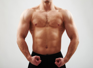 Fototapeta na wymiar Close-up of bare male torso on white background
