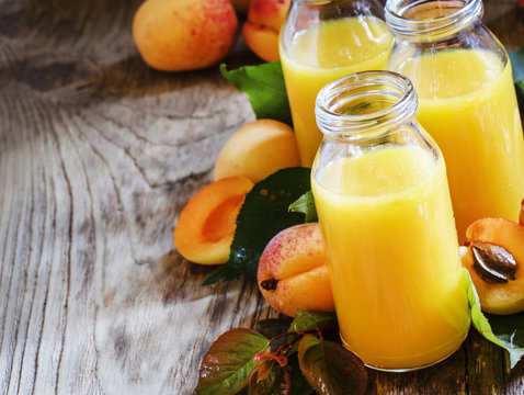 Freshly squeezed apricot juice in glass bottles, fresh fruit wit