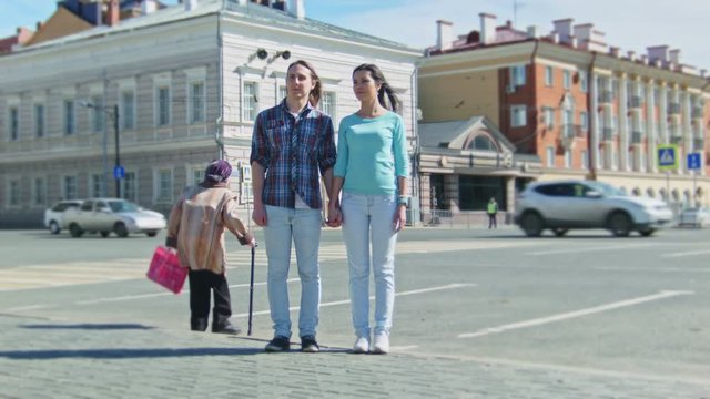 Cute girl and boy with long hair standing on the street time-lapse