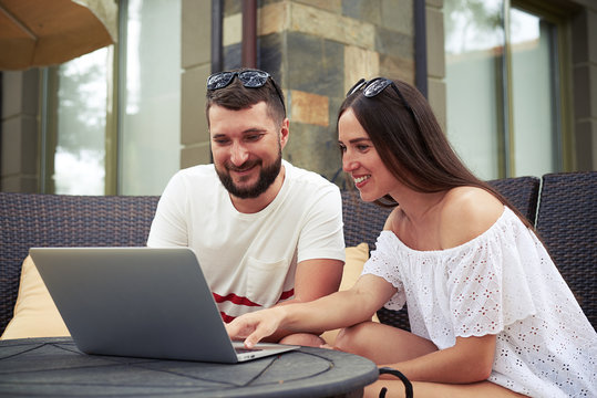 Smiling woman and man with laptop in the yard