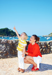 Mother and daughter pointing on something in front of lagoon