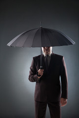 Businessman under umbrella
