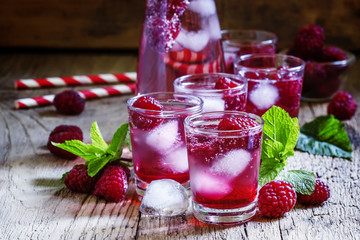 Sweet cocktail with raspberries, ice and soda, vintage wooden ba