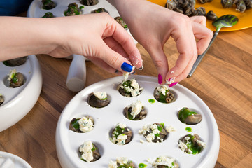 Preparing snails with herbs and blue cheese.