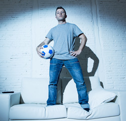  attractive man standing on top home sofa couch holding ball cool defiant in bad boy attitude style
