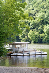 Fototapeta na wymiar Houseboat on the River – A houseboat tied to a dock on the river.