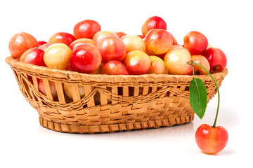 yellow cherries in a wicker basket isolated on white background