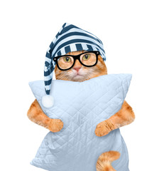Sleepy cat in a cap with a pillow.  Isolated on white.
