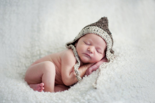 Newborn baby boy asleep in knit hat