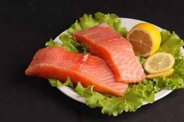 salmon on a plate with salad and lemon