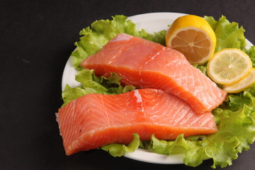 salmon on a plate with salad and lemon