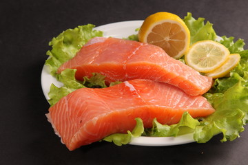 salmon on a plate with salad and lemon