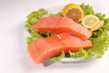 salmon on a plate with salad and lemon