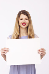 Naklejka premium happy woman holding white blank paper