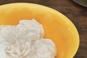  whipped cream in a yellow bowl - closeup 