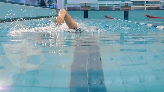 Man swimming crawl in the pool with splash arm