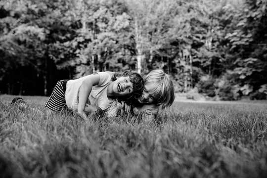 Two young brothers, fooling around, laughing, outdoors, black and white