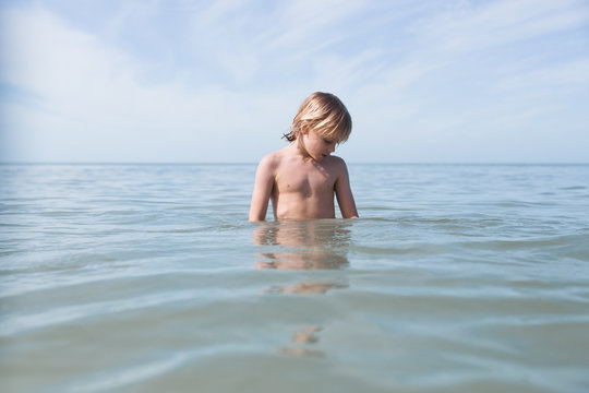 Young boy standing in sea