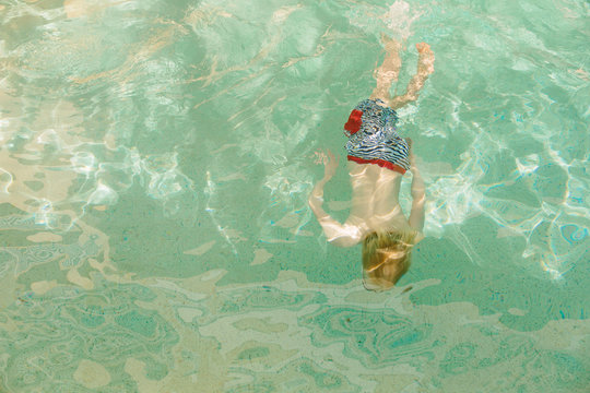Young boy swimming underwater, overhead view